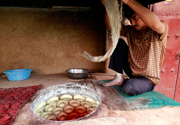 A man makes naan bread. Chen Tao A man makes naan bread. Chen Tao