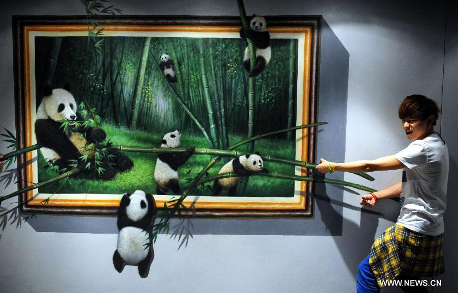 A visitor poses for a photo with a 3D painting at the HK 3D Museum in Hong Kong, south China, June 26, 2014. The 3D art museum, the first of this kind in Hong Kong, was unveiled here on Thursday. [Photo/Xinhua]