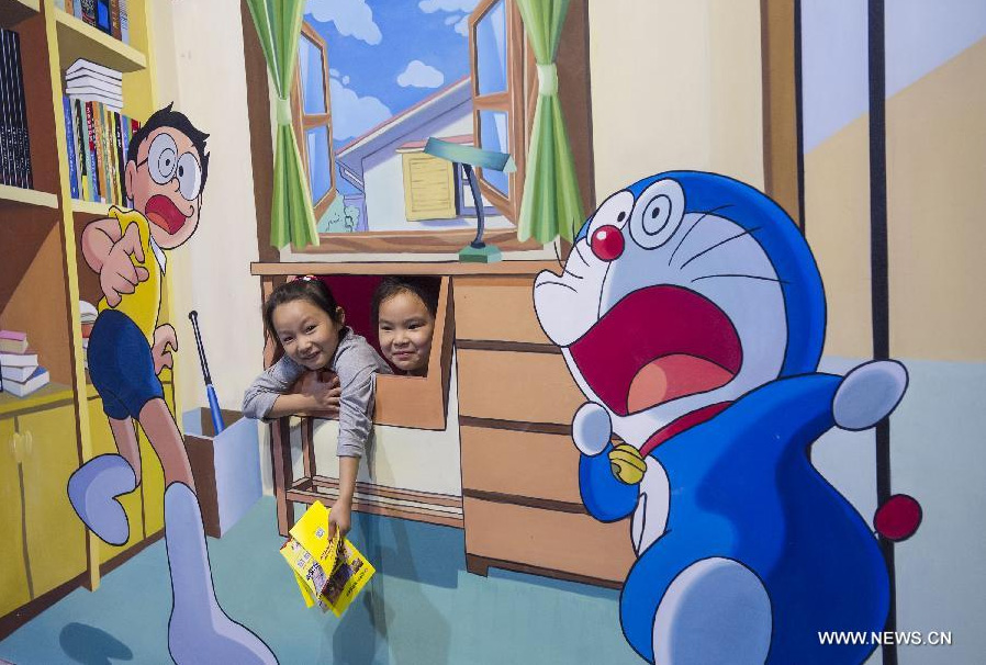 Two kids pose for photo during a 3D painting exhibition in southwest China's Chongqing, June 26, 2014. Over 200 pieces of 3D painting were on display. [Photo/Xinhua]